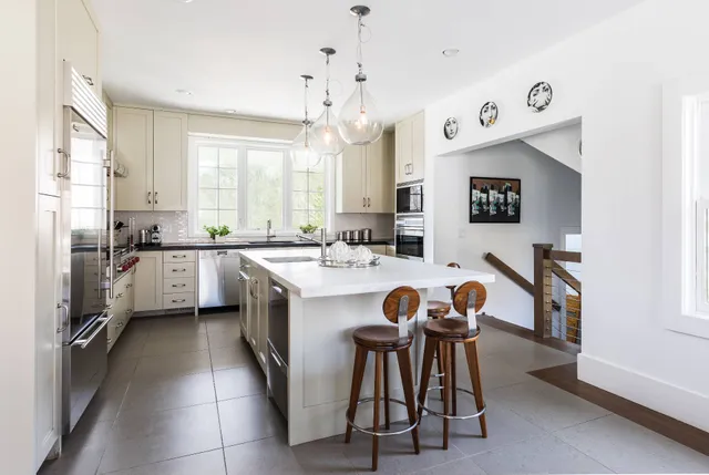 a large kitchen with a large window and stainless steel appliances