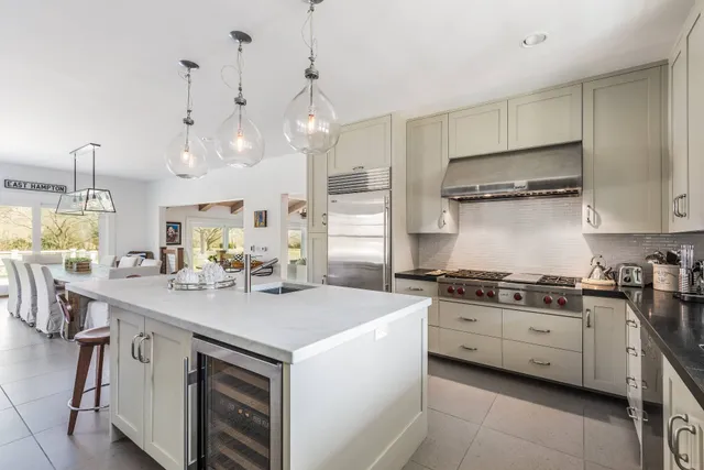 a kitchen with stainless steel appliances granite countertop a sink a stove and a refrigerator