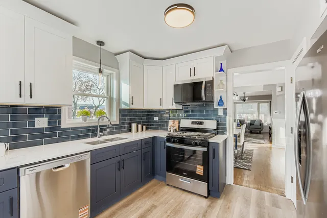 a kitchen with a sink stainless steel appliances and white cabinets