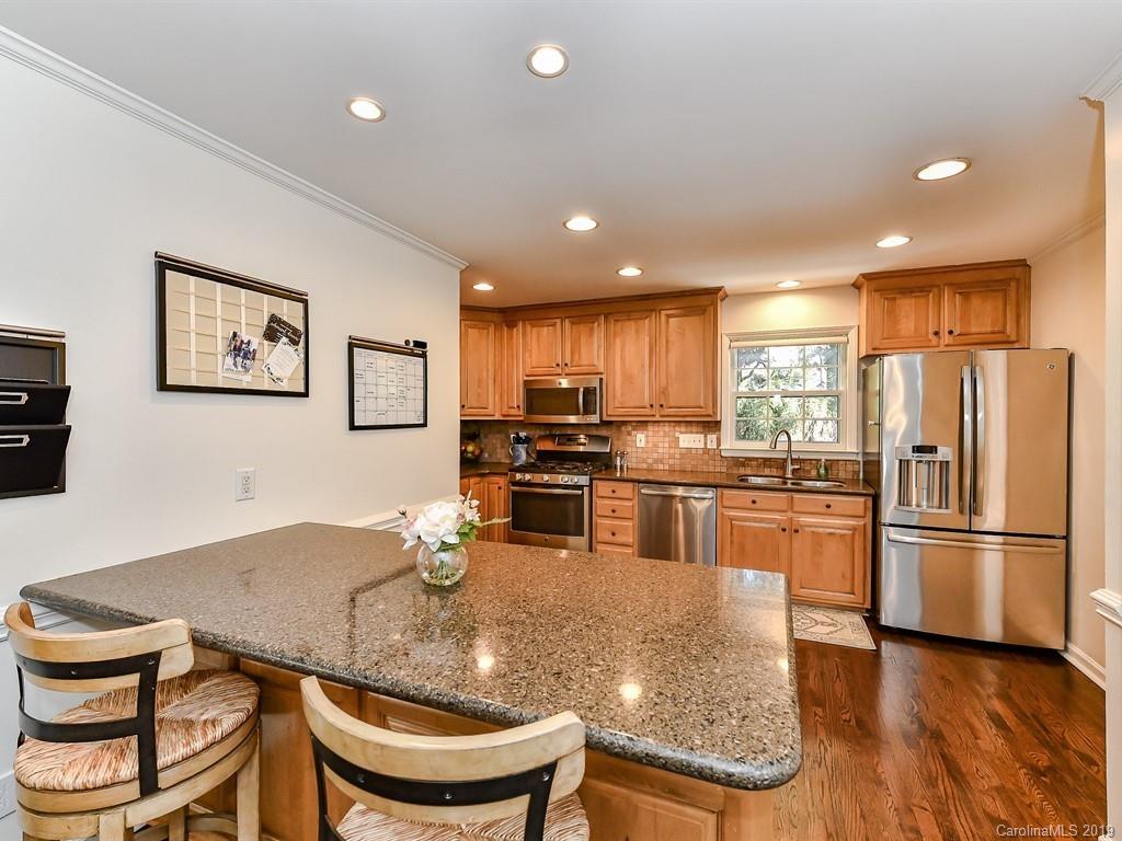 5300 Guildbrook Road Charlotte, NC 28226 - Photo 13 of 35 a kitchen with granite countertop a refrigerator a stove a sink a dining table and chairs