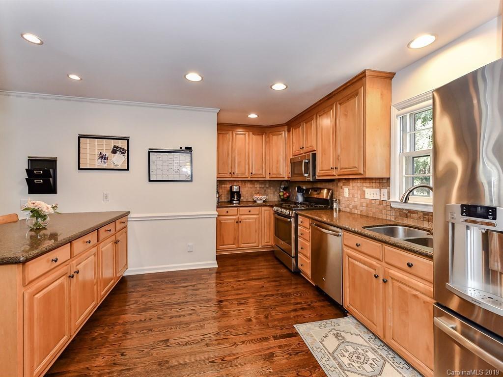 5300 Guildbrook Road Charlotte, NC 28226 - Photo 14 of 35 a kitchen with stainless steel appliances granite countertop a stove top oven a sink dishwasher a refrigerator and cabinets with wooden floor