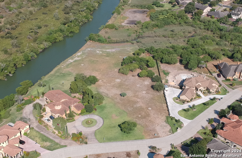 an aerial view of a house with a yard and lake