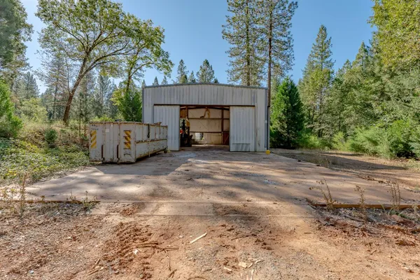 a view of a house with backyard and trees