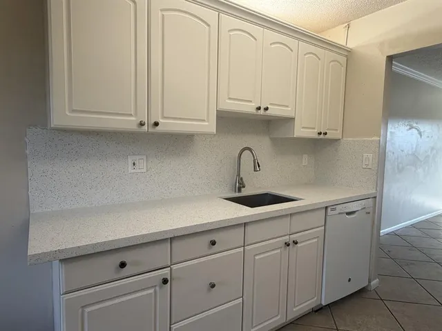 a kitchen with white cabinets and a sink