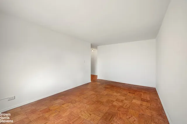a view of a room with wooden floor and mirror