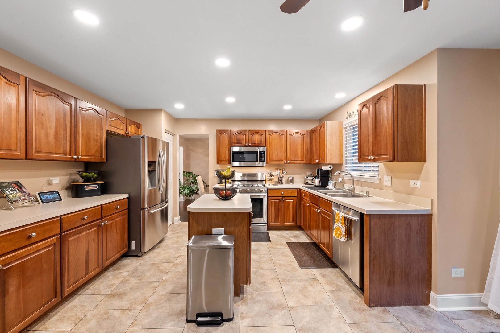 327 Berkeley Drive Bolingbrook, IL 60440 - Photo 16 of 50 a large kitchen with kitchen island wooden cabinets stainless steel appliances a sink and a counter top space