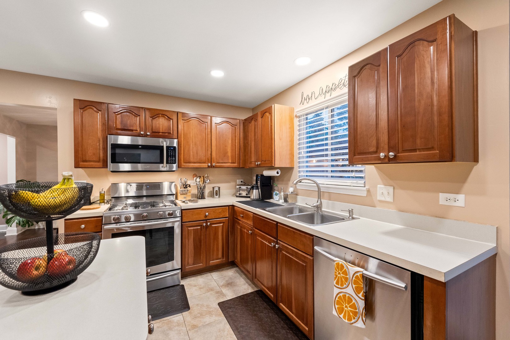327 Berkeley Drive Bolingbrook, IL 60440 - Photo 18 of 50 a kitchen with stainless steel appliances granite countertop a sink stove and microwave