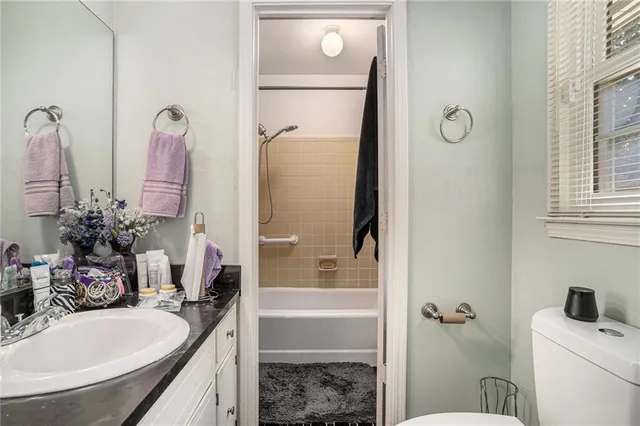 a bathroom with a tub sink vanity and mirror