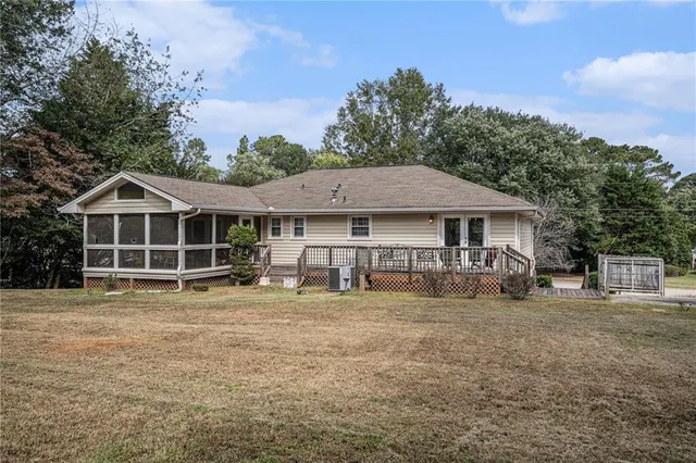 a front view of a house with yard and trees in the background