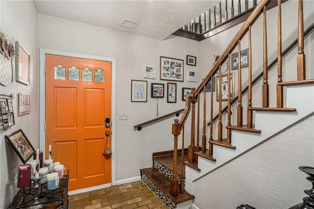 a view of staircase with lots of frames on wall and a window