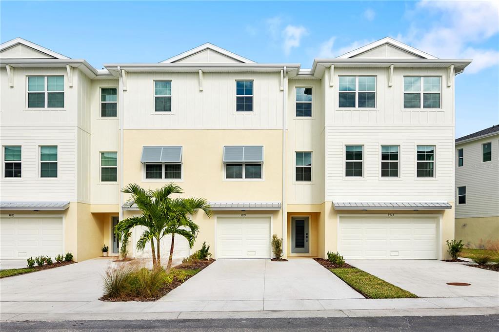a view of a white house with large windows and a table and chairs