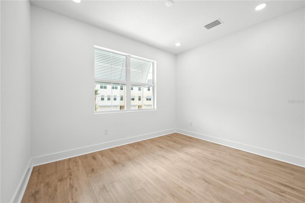 9975 Key Haven Road Seminole, FL 33777 - Photo 21 of 56 an empty room with wooden floor and windows
