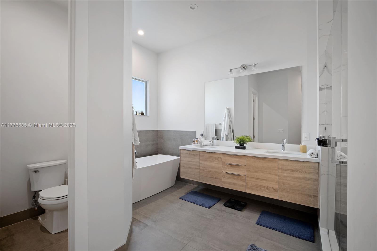 6425 Southwest 27th Street Miami, FL 33155 - Photo 13 of 27 a bathroom with a granite countertop toilet a sink and a bathtub