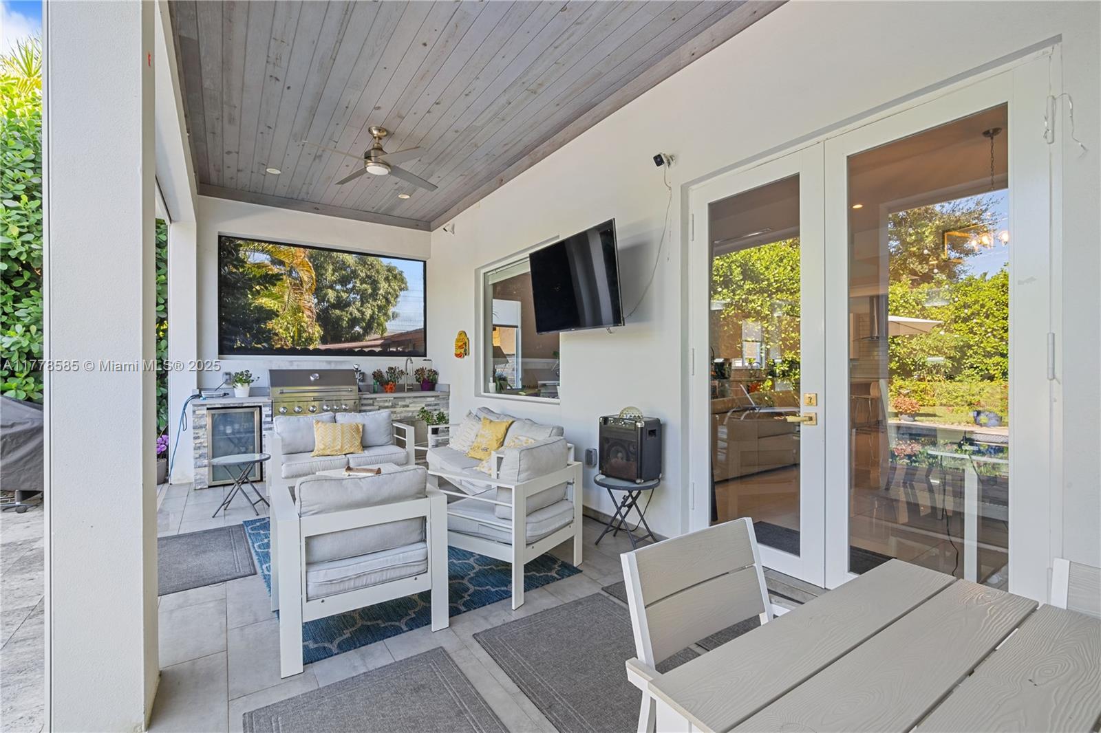 6425 Southwest 27th Street Miami, FL 33155 - Photo 20 of 27 a living room with furniture a flat screen tv and a floor to ceiling window