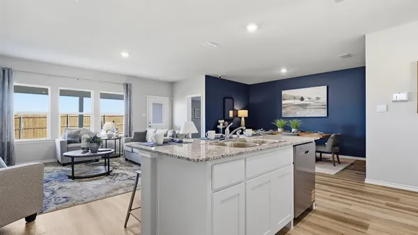 a kitchen with refrigerator and chairs