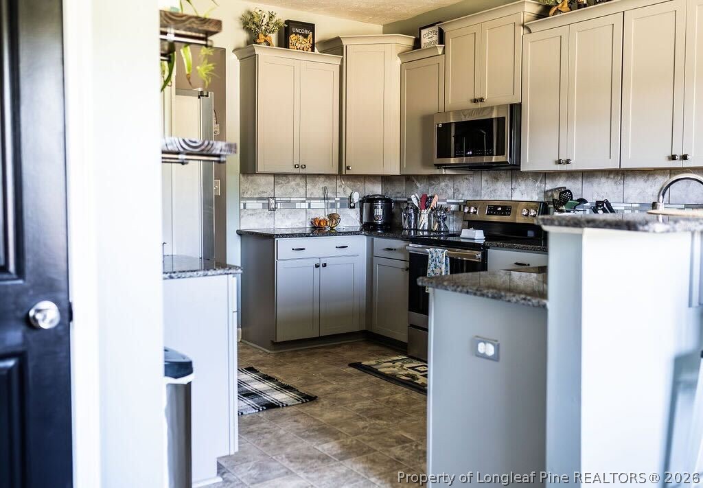 210 McGougan Road Lumber Bridge, NC 28357 - Photo 13 of 47 a kitchen with stainless steel appliances granite countertop a refrigerator a stove top oven a sink and dishwasher