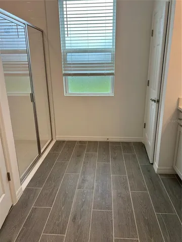 a view of a room with wooden floor and a window