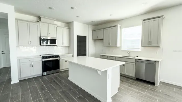 a kitchen with a stove a sink and a microwave