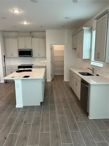 a kitchen with a sink a stove and cabinets