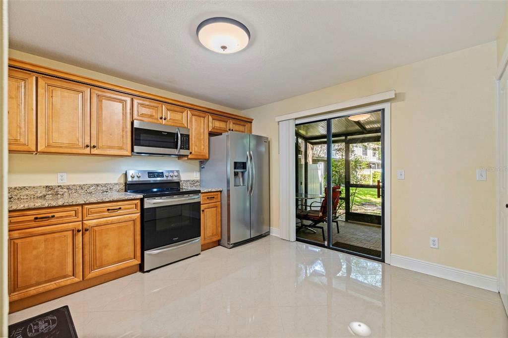 5100 Burchette Road, Unit 2301 Tampa, FL 33647 - Photo 11 of 39 a kitchen with stainless steel appliances granite countertop a stove top oven a sink dishwasher a refrigerator and a microwave with wooden floor