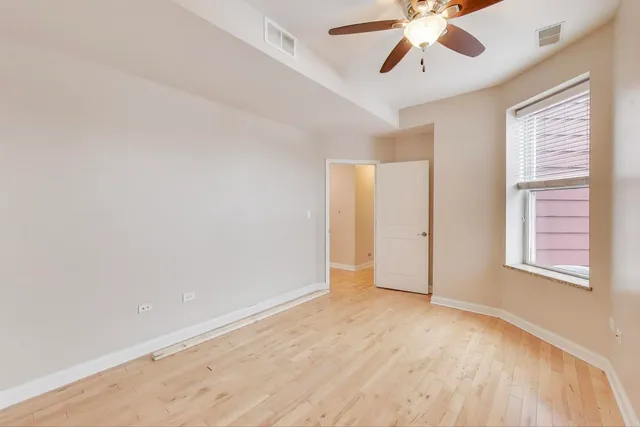 an empty room with windows and fan