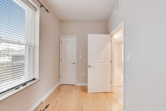 a view of an empty room with closet and a window