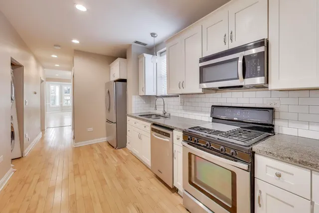 a kitchen with stainless steel appliances a stove microwave and sink