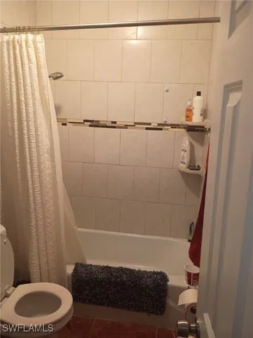 a bathroom with a shower curtain and sink