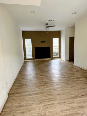 a view of an empty room with a fireplace and a window