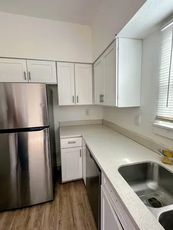 a kitchen with a refrigerator sink and cabinets
