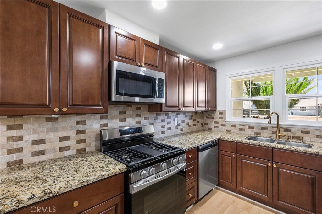 10597 Pendleton Street Riverside, CA 92505 - Photo 12 of 40 a kitchen with granite countertop wooden cabinets and a stove top oven