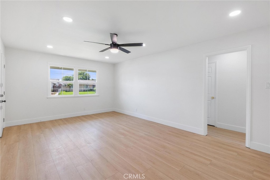 10597 Pendleton Street Riverside, CA 92505 - Photo 6 of 40 an empty room with wooden floor ceiling fan and windows