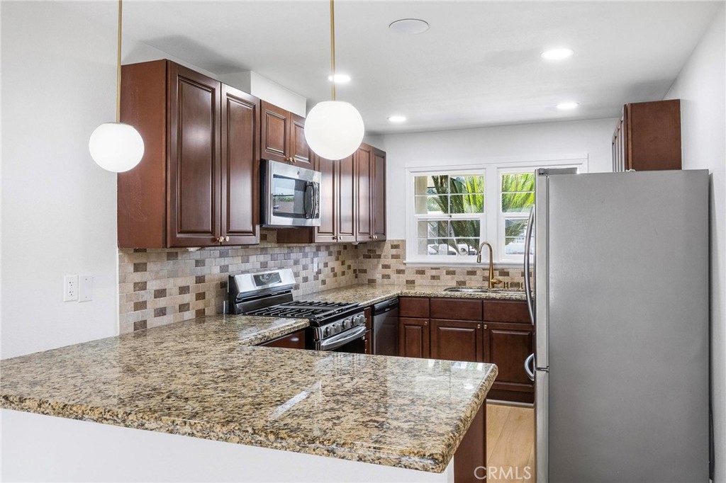 10597 Pendleton Street Riverside, CA 92505 - Photo 10 of 40 a kitchen with stainless steel appliances granite countertop a sink stove and refrigerator