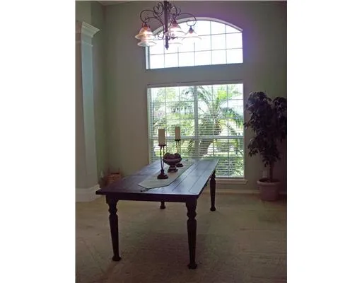 a view of a workspace room with furniture and a window