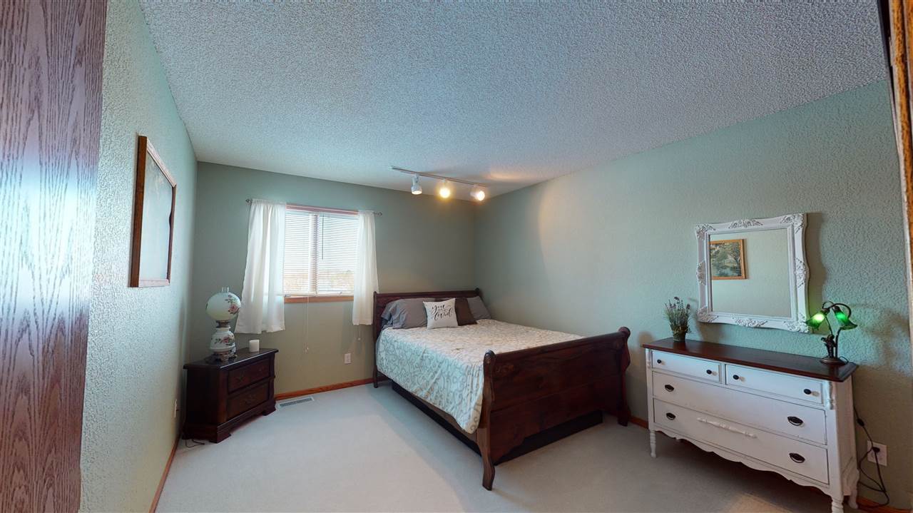 3028 South Golf Road Stockton, IL 61085 - Photo 17 of 26 a bedroom with a bed and a potted plant