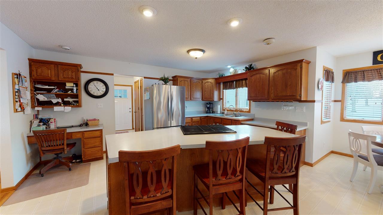 3028 South Golf Road Stockton, IL 61085 - Photo 8 of 26 a kitchen with stainless steel appliances granite countertop a stove a refrigerator a sink a dining table and chairs with wooden floor