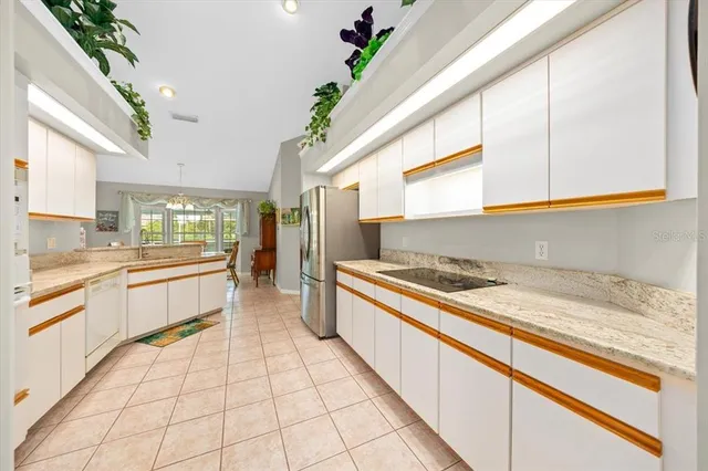a large white kitchen with a stove a sink and dishwasher