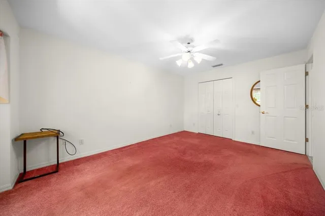 an empty room with closet and windows
