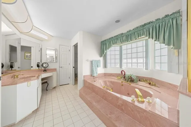 a spacious bathroom with a tub sink and mirror