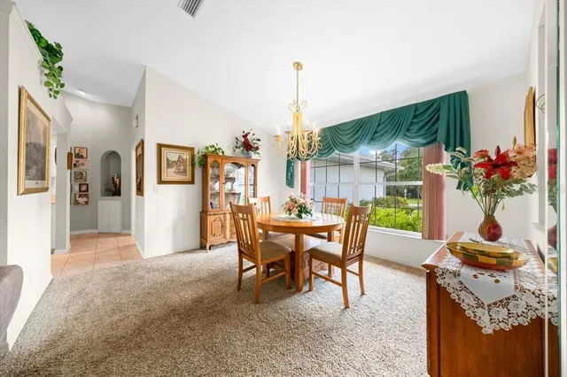 a dining room with furniture potted plants and wooden floor