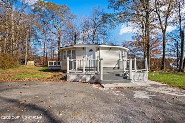 a view of a house with backyard and a tree