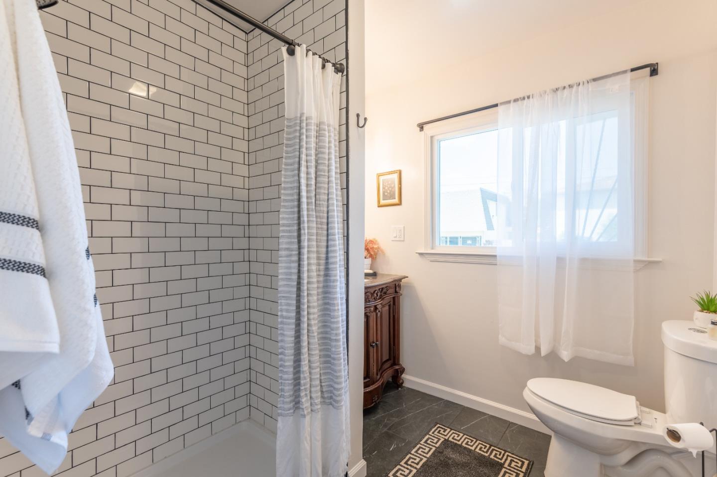 416 Front Street Salinas, CA 93901 - Photo 35 of 48 a bathroom with a granite countertop window a toilet and a shower