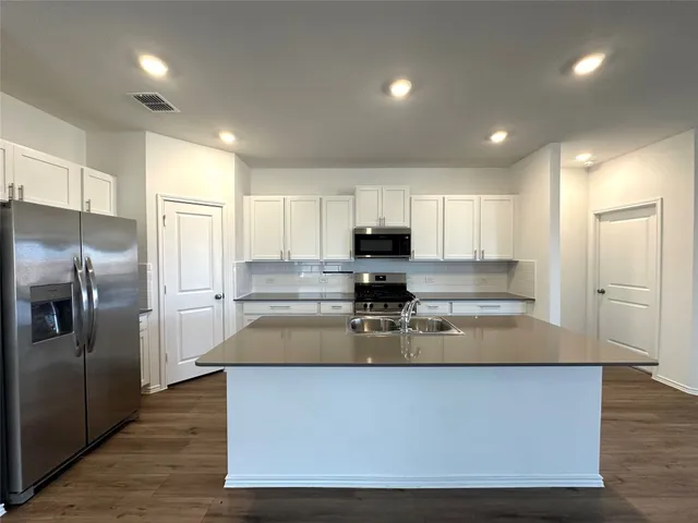 a kitchen with stainless steel appliances granite countertop sink stove and refrigerator
