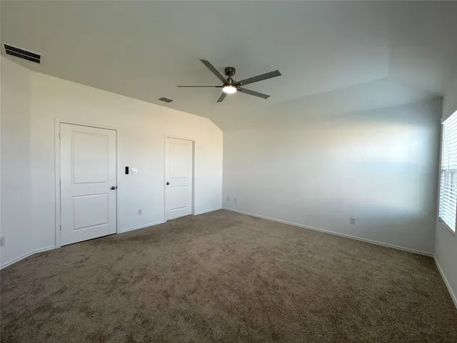 an empty room with a window and a fan