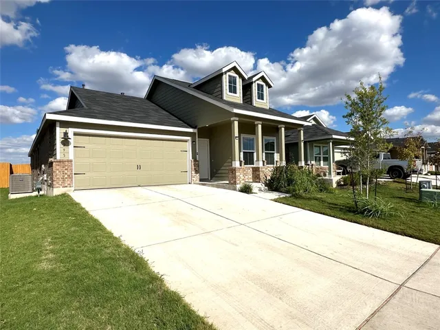 a front view of a house with a yard and potted plants