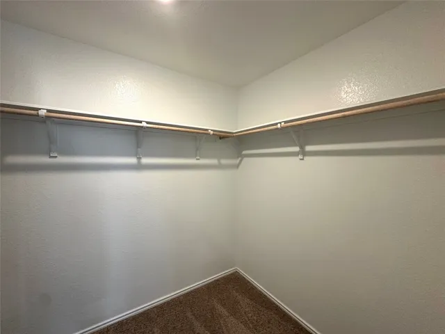 an empty room with a ceiling fan and a window