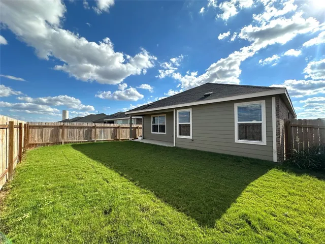 a view of a big yard with a large tree and a garden