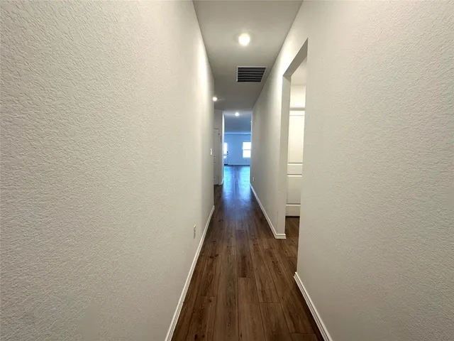 a view of a hallway with wooden floor