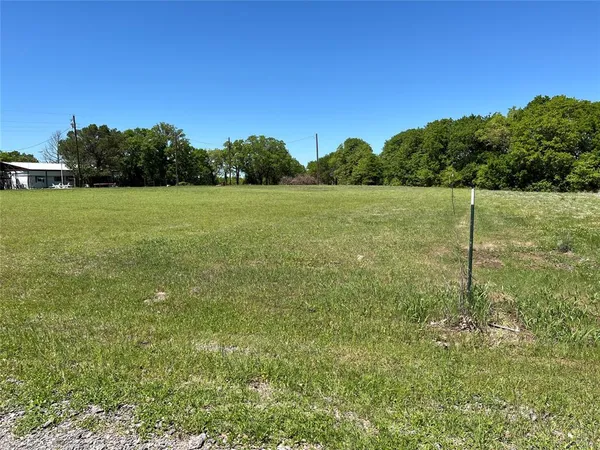 a view of a green field with wooden fence
