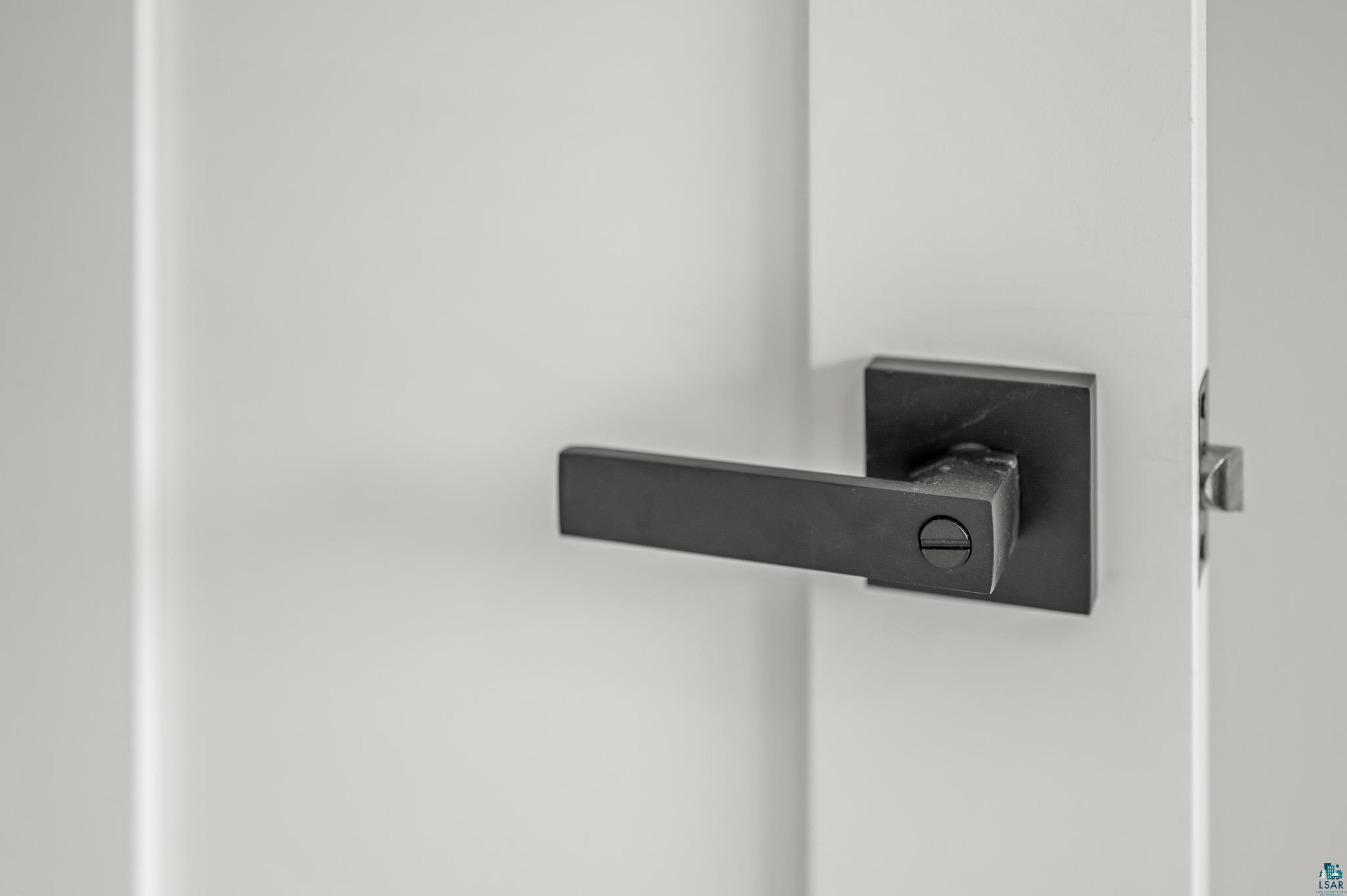 1241 Airport Road Two Harbors, MN 55616 - Photo 30 of 54 Modern matte black lever-style door handle with integrated privacy lock mechanism, mounted on a sleek dark escutcheon plate against a clean white door frame
